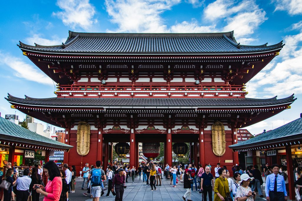 Visitors walking beneath the traditional Hozomon Gate at Sensoji Temple in Asakusa, Tokyo.